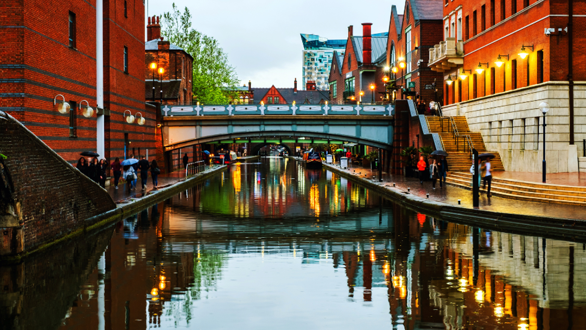 View of the a central Birmingham canal surrounded by large commercial buildings.